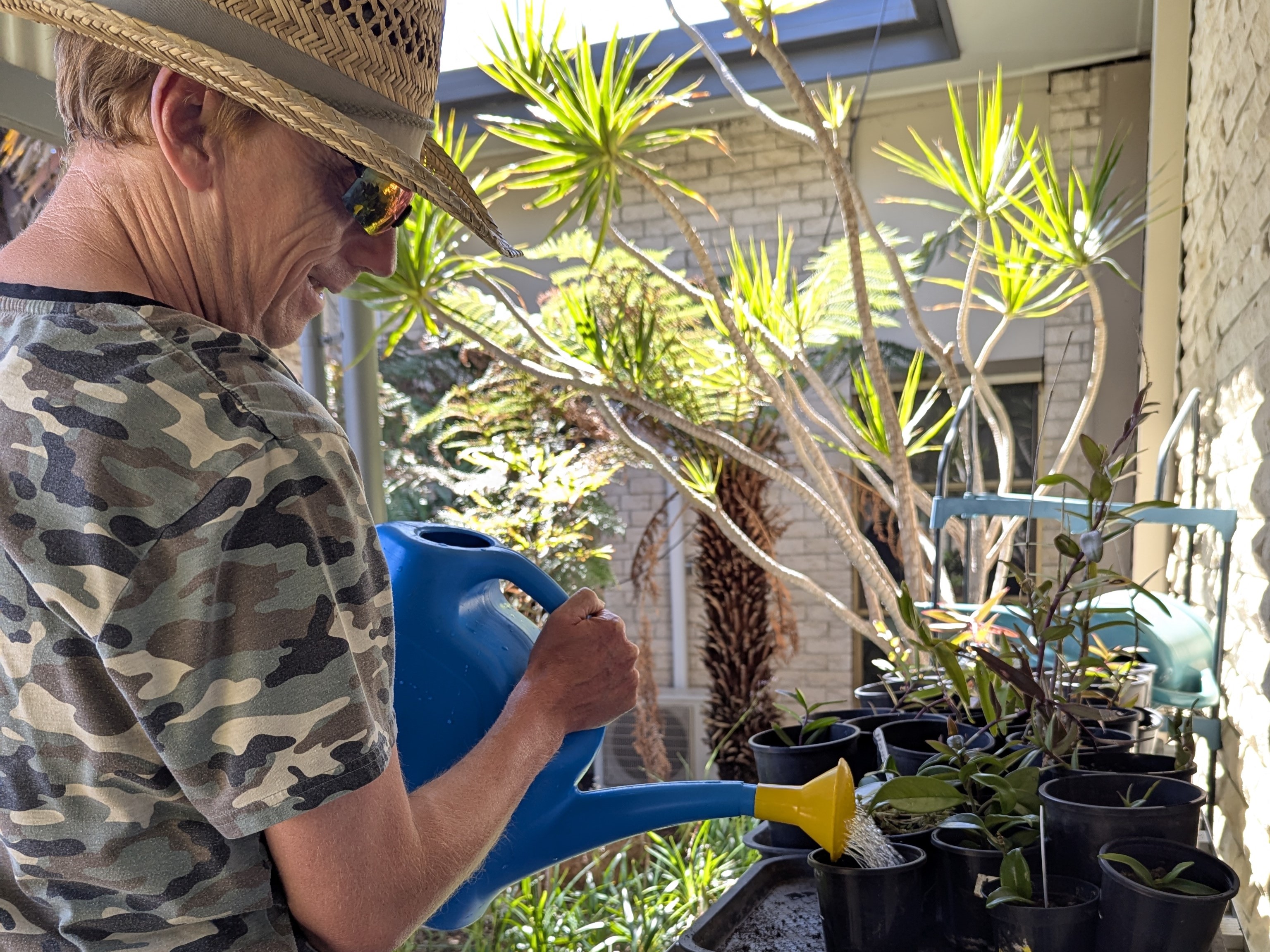 a man watering plants at Distinctive Options Noweyung