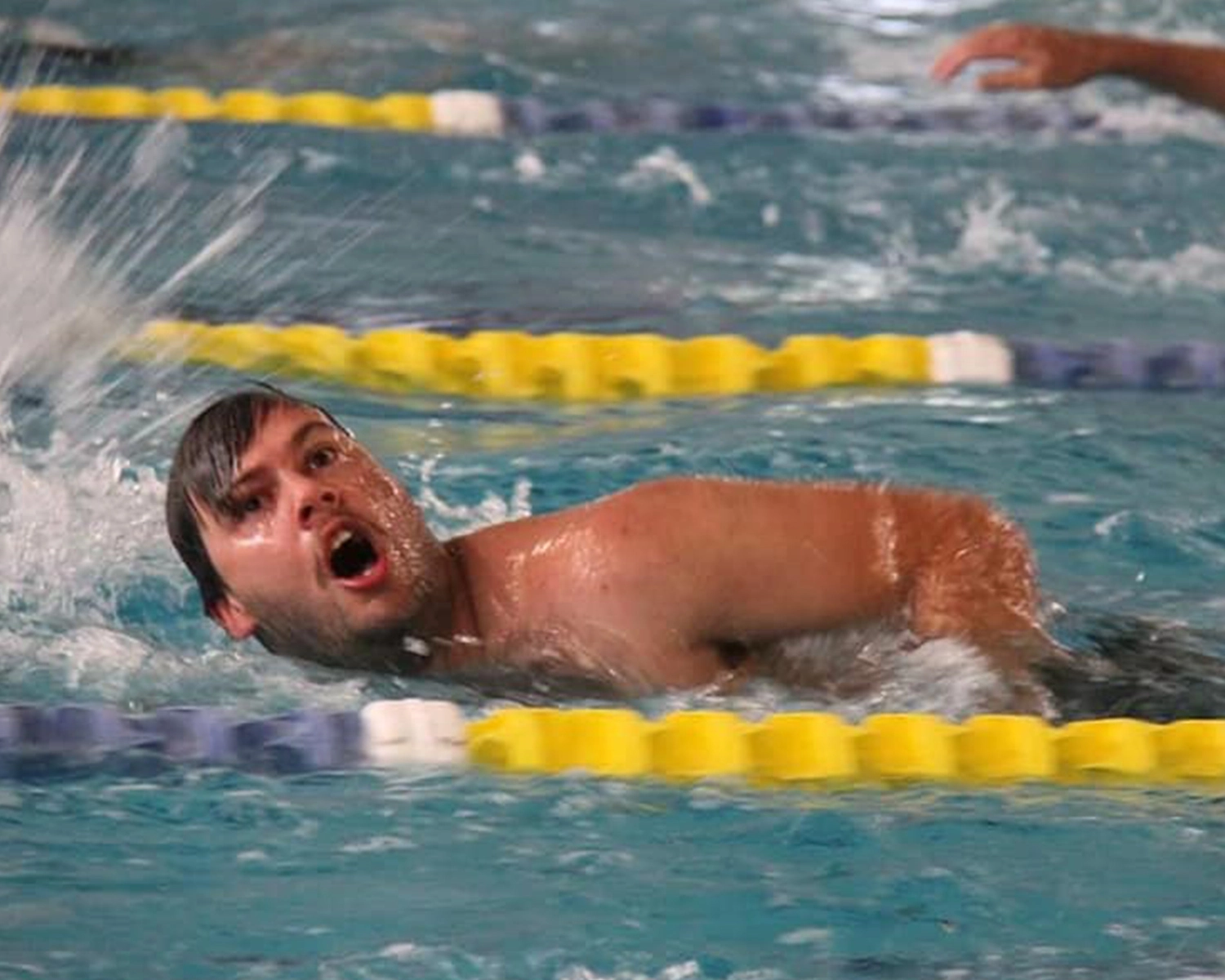 A man swims in a pool at NDIS registered disability support Distinctive Options