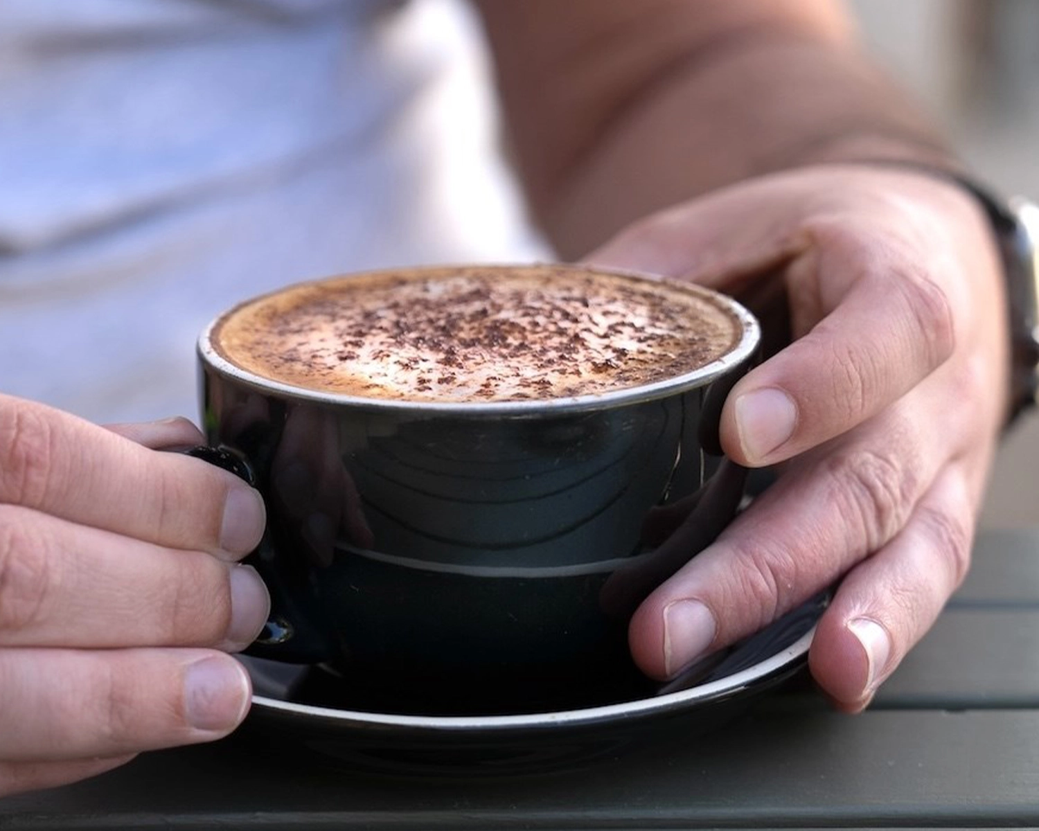 A pair of hands around a cup of coffee at NDIS registered disability service Distinctive Options