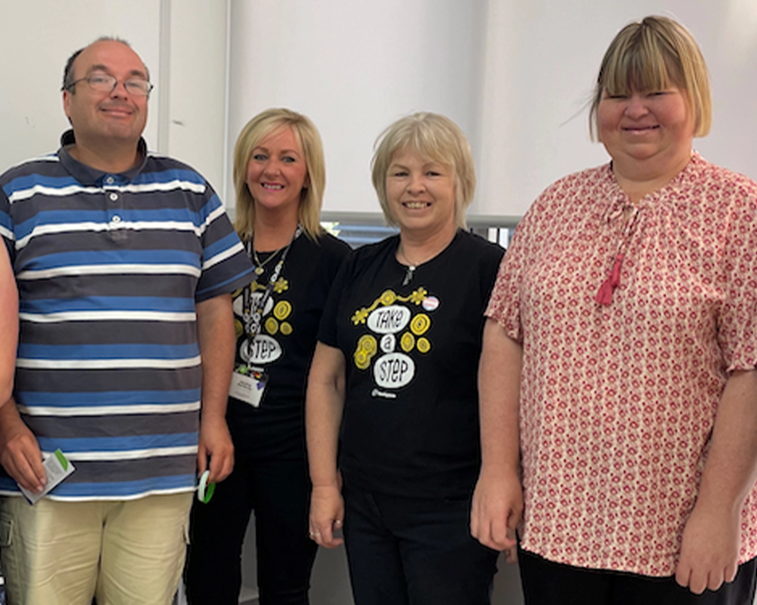 Four people stand in a group smiling