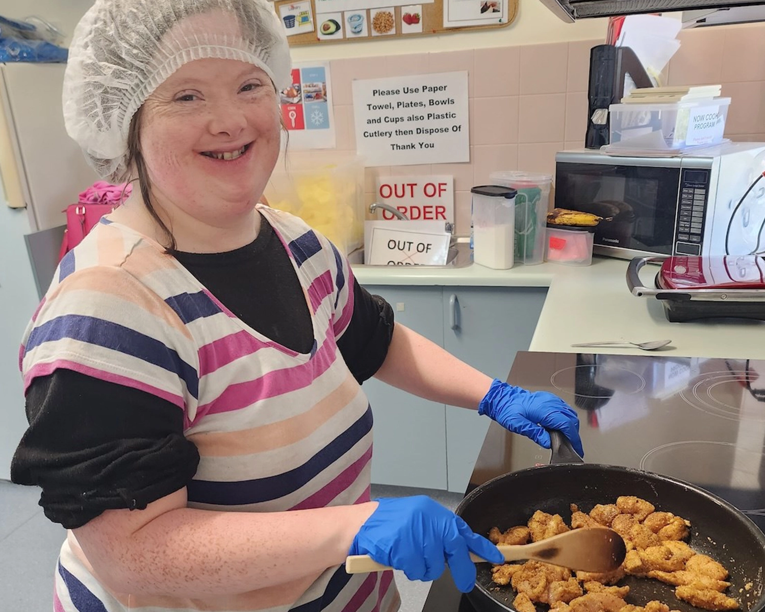 a woman cooks a meal at Group Supports Cooking Program at Distinctive Options Noweyung