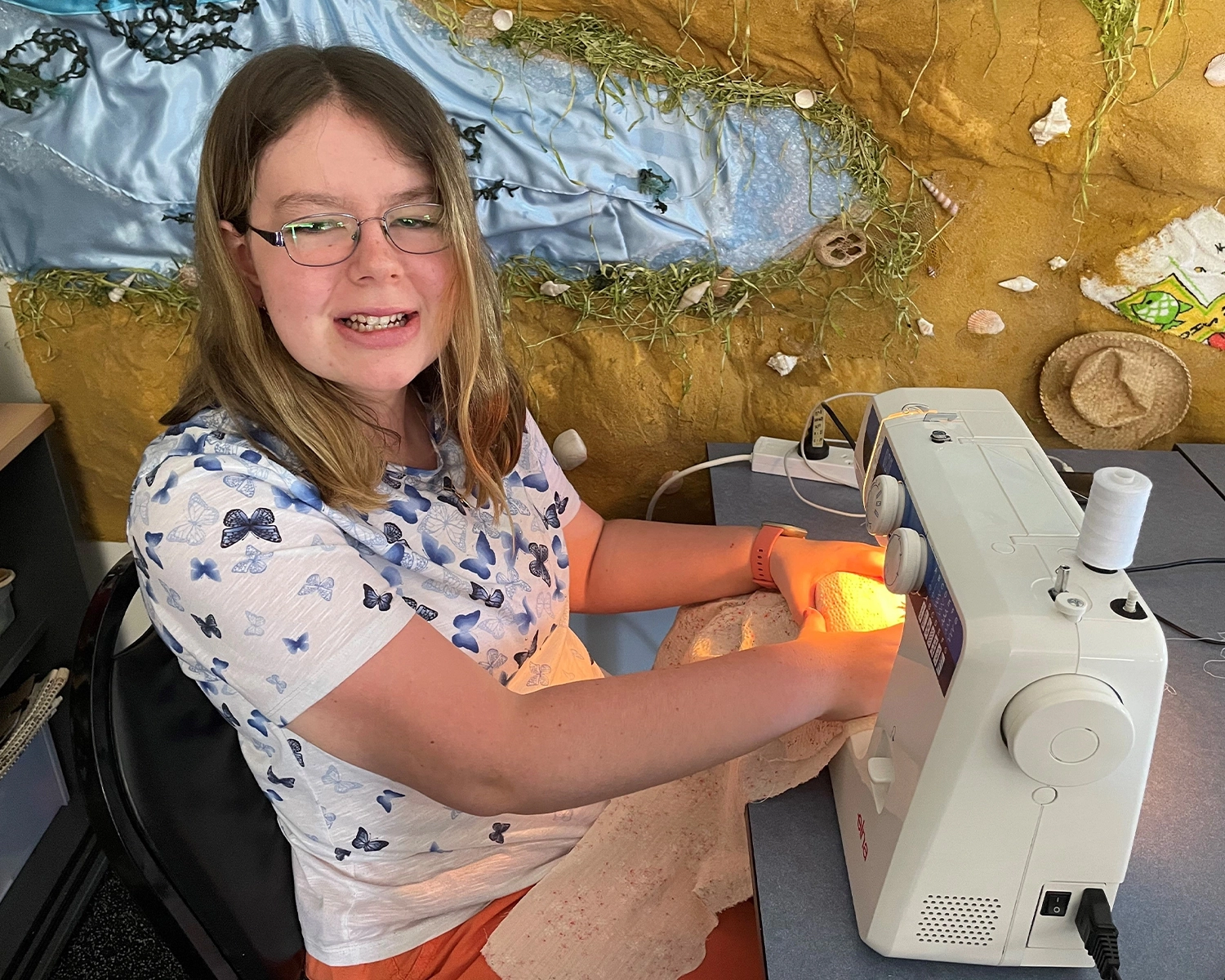 A woman operates a sewing machine at Group Supports Creative Arts at Distinctive Options Noweyung
