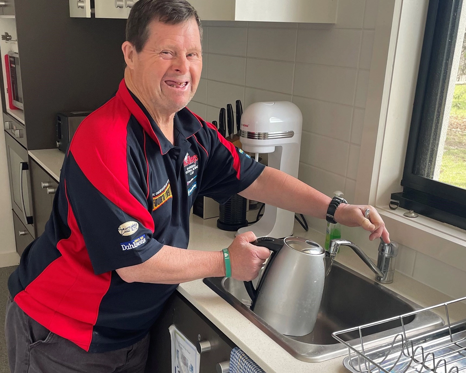 Man filling kettle with water in his supported accomodation