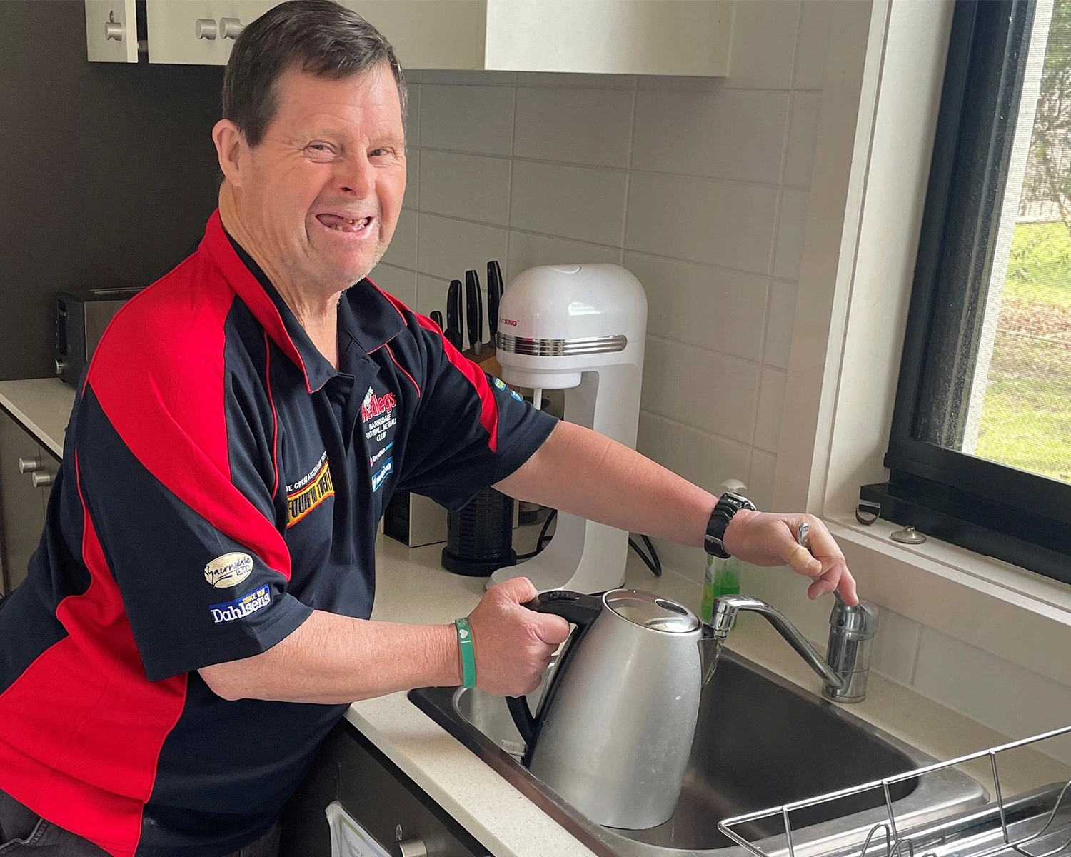 A man fills a kettle in the kitchen at Supported disability accommodation in Bairnsdale with Distinctive Options