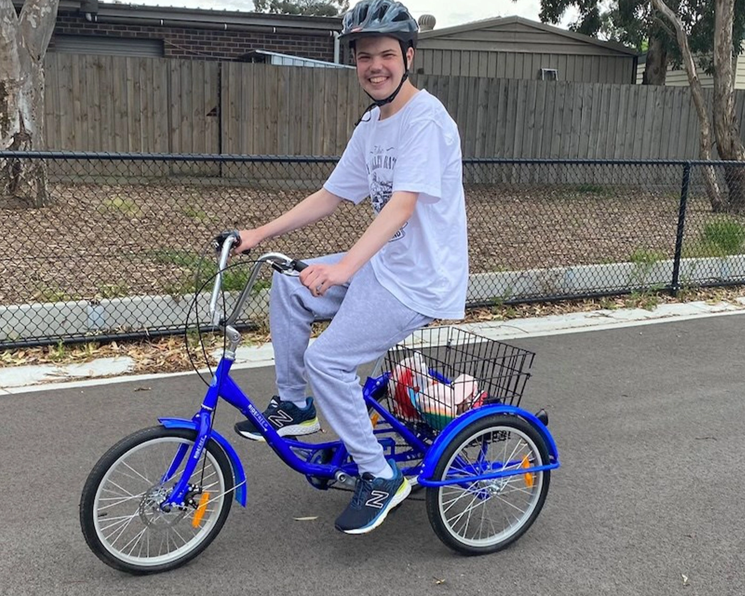 A man rides a tricycle at NDIS registered disability service Distinctive Options