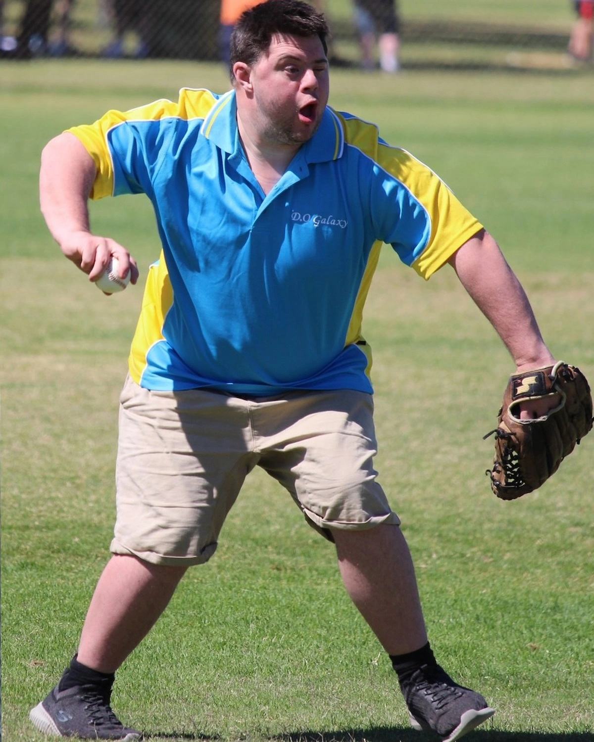 A man throws a ball on a sports' pitch at NDIS registered disability service Distinctive Options