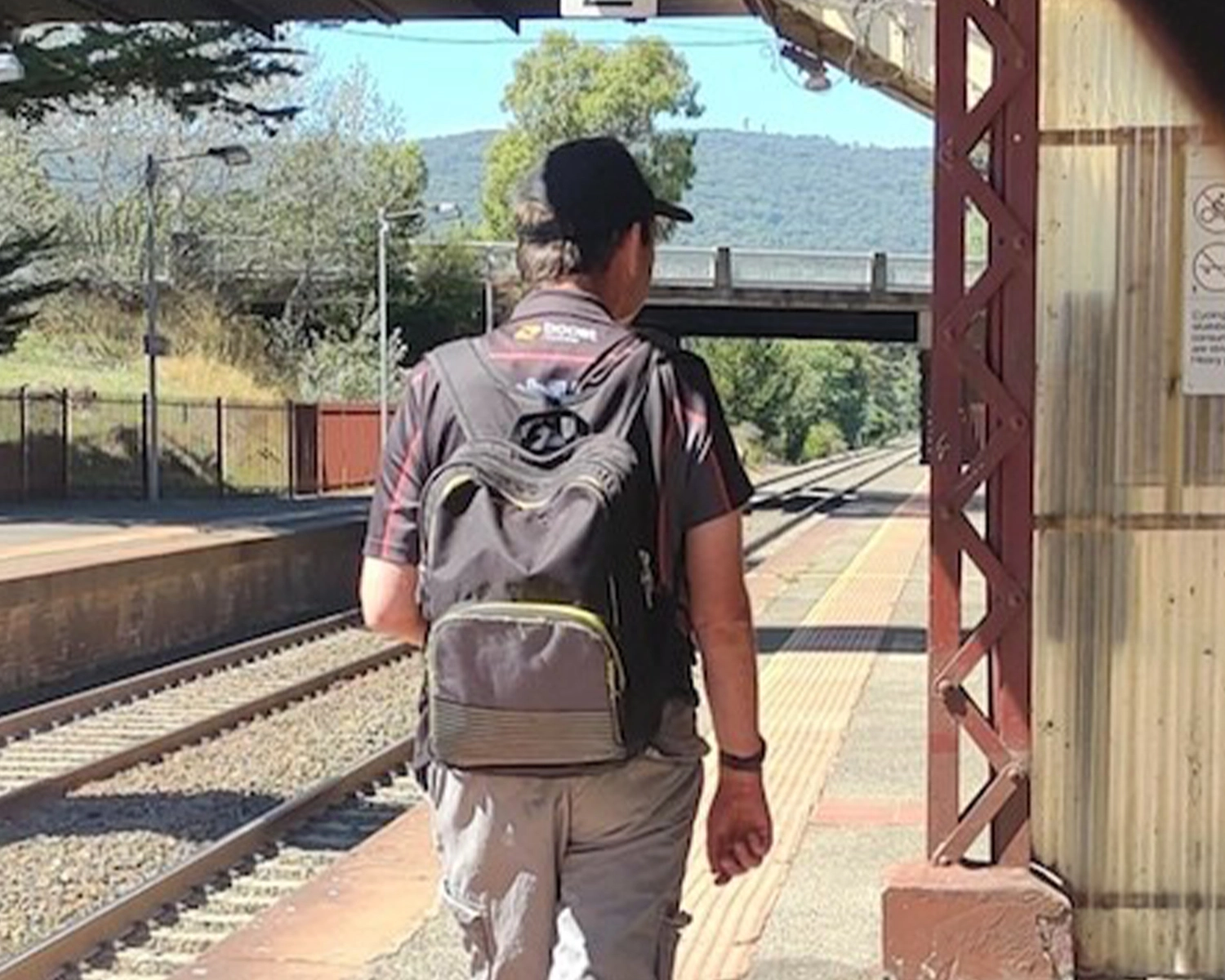 A man walks along a railway station platform