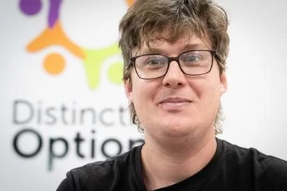 A young man smiles at camera.